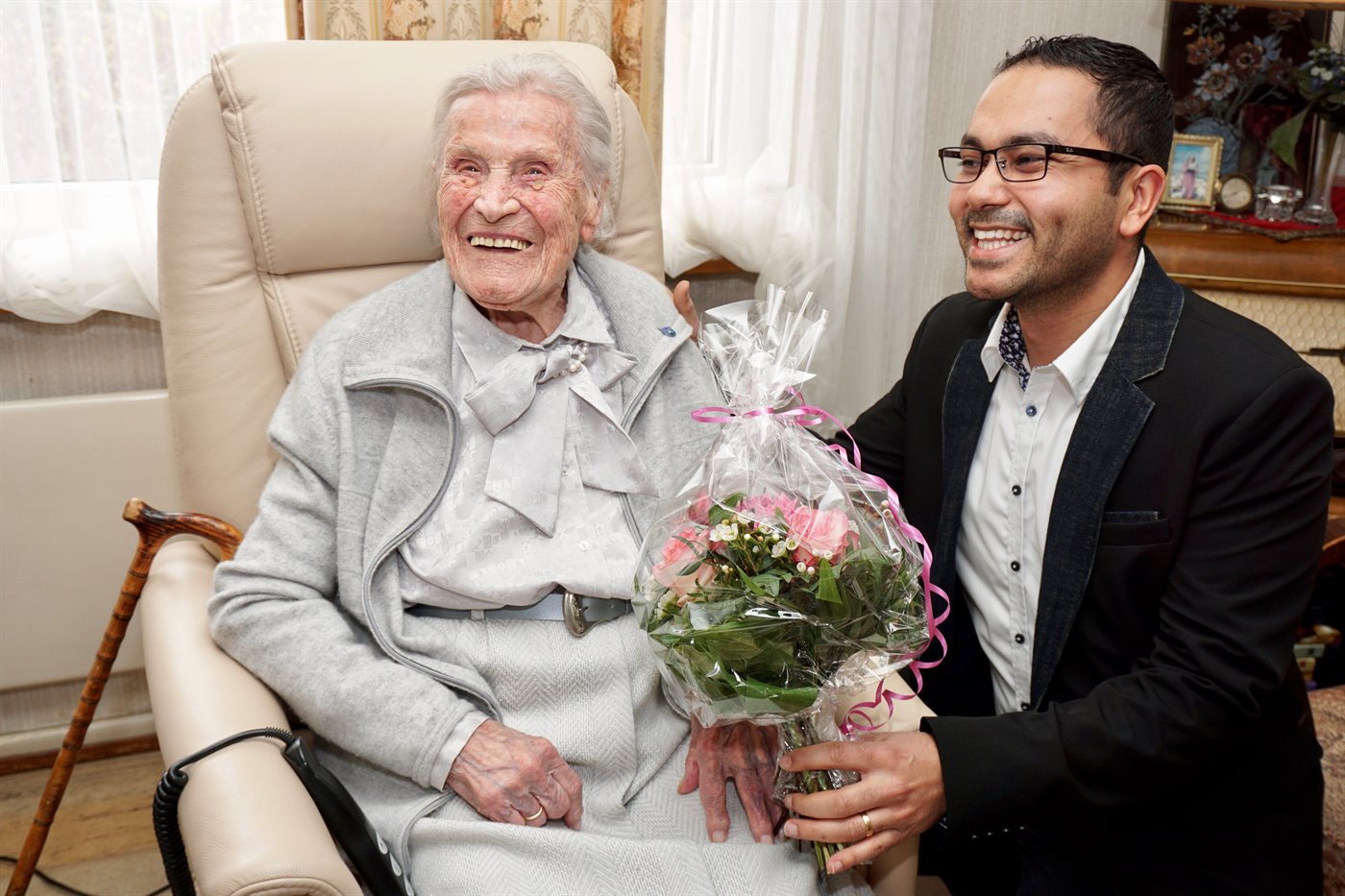 Betreuungskraft mit einer lächelnden Seniorin zu Hause